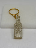 Porte-clé bouteille en résine transparente et paillettes dorées